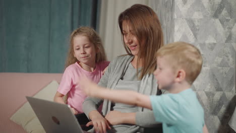 curious preschooler and toddler watch mommy using gadget