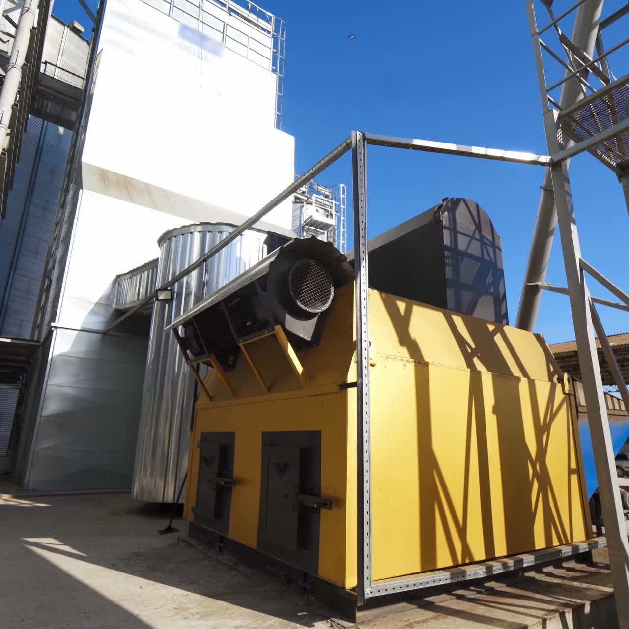 Industrial equipment on agricultural plant. Exterior of modern factory for grain processing. New equipment for agribusiness. Grain elevator