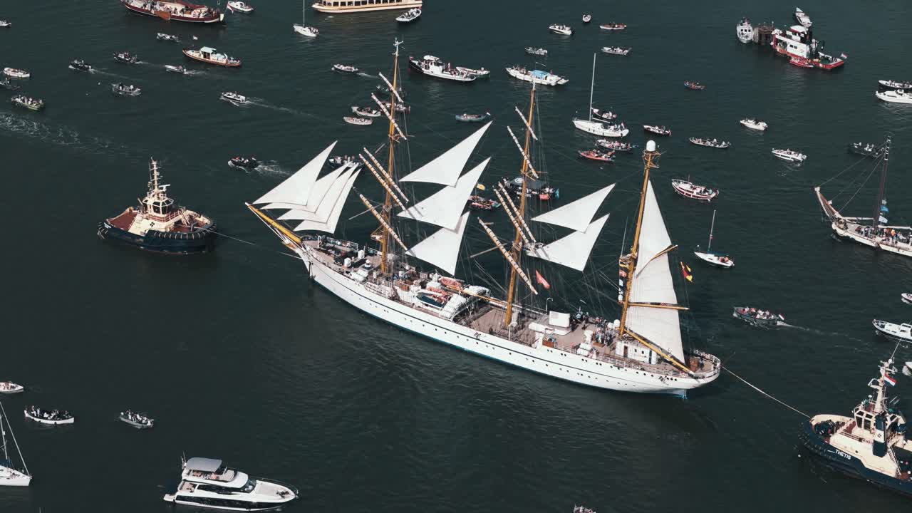 Aerial orbit of large white sailing vessel among festival crowd in Amsterdam bay during Sail festival