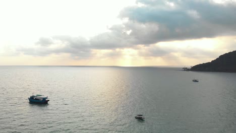 Golden-cloudy-evening-shrouding-Lazy-Beach-coast-on-the-island-of-Koh-Rong-Samloem-off-the-coast-of-Sihanoukville,-Cambodia---Aerial-Fly-over-shot