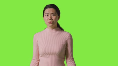녹색 스크린 2 에 맞서 서 있는 좌절 하거나 화가 난 여자 의 스튜디오 초상화