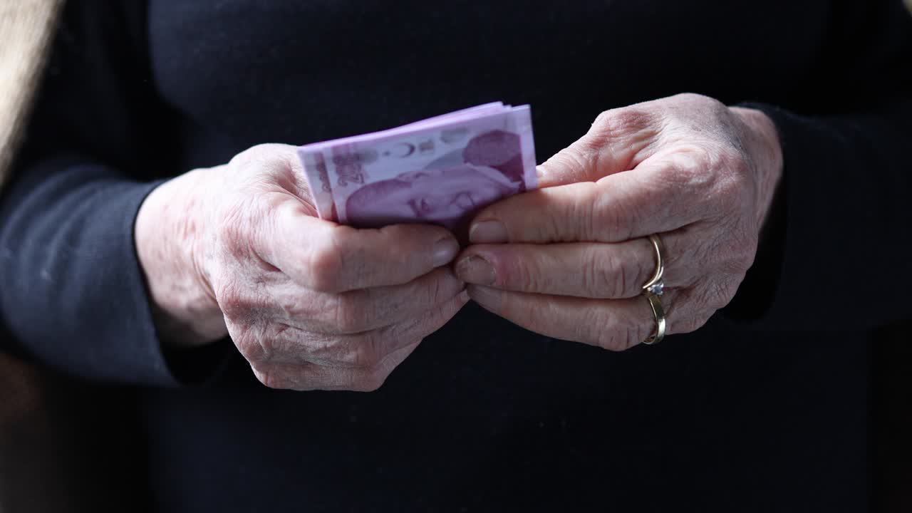 은퇴 한 노인 이 돈 을 세고 있다