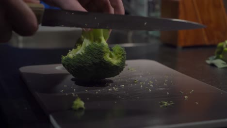Low-angle-close-up:-Broccoli-crown-cut-into-florets-on-cutting-board