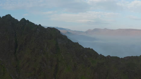 Vista-Aérea-Del-Panorama-Brumoso-De-Las-Montañas-Nubladas-Y-Brumosas-En-Islandia.-Vista-De-Drones-De-La-Cresta-De-Las-Montañas-Rocosas-En-El-Campo-Del-Sur-De-Islandia