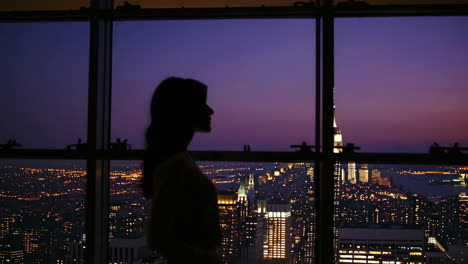woman silhouetted against nyc skyline at sunset