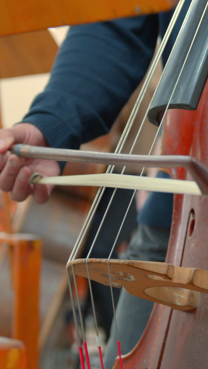 Close-up of a Musician's Hand Playing Cello with a Bow