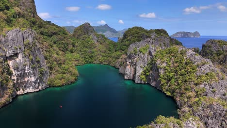 drone shot over big lagoon on miniloc island, el nido, palawan, showcasing towering karst limestone formations enclosing vibrant turquoise waters linked to the bacuit bay of the south china sea