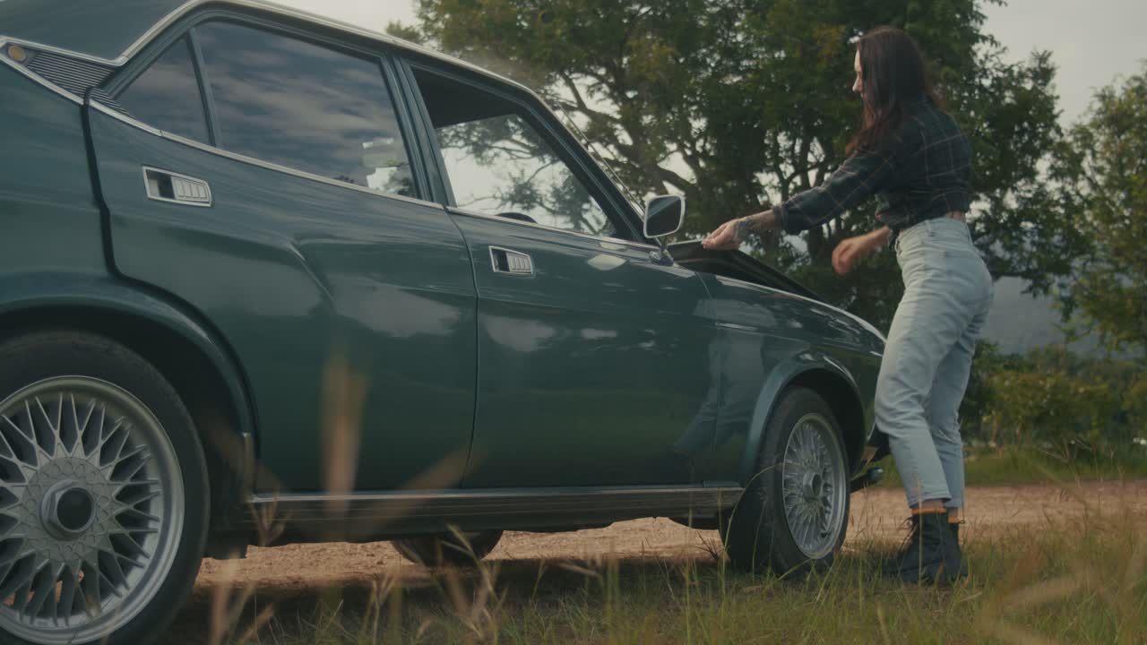 Woman Getting Out of a Vintage Car in the Countryside