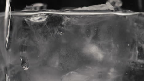 frozen cubes sparkling water closeup slow motion. tonic pure cocktail concept