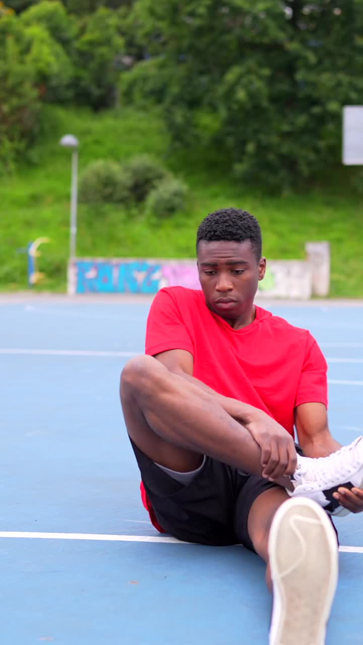 Young man stretching on a basketball court