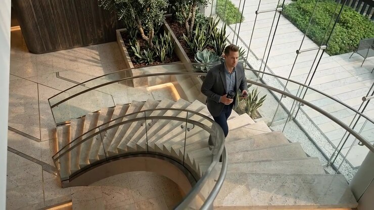 Profissional caminhando pelo átrio de um escritório moderno e interior corporativo