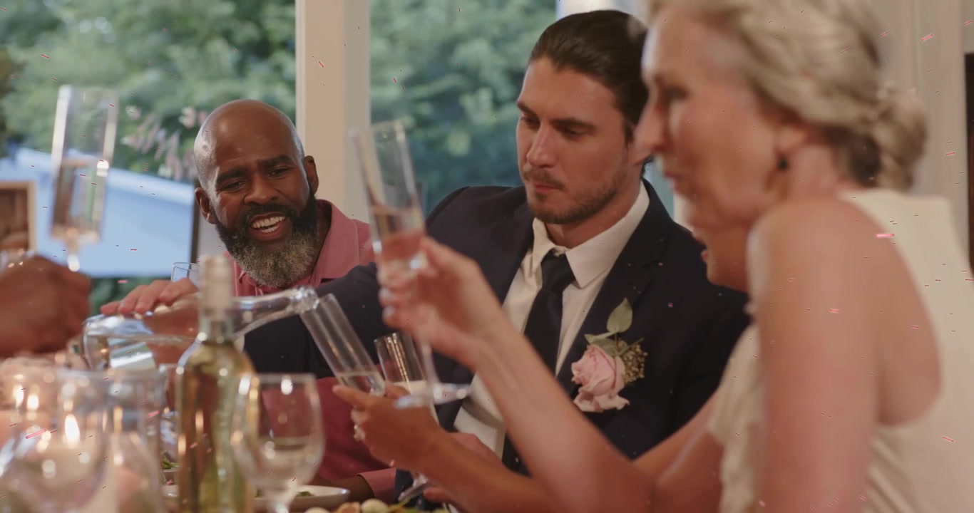 Eldre mann løfter champagneflaske og heller i champagneglass for skål under bryllupsmottakelse.