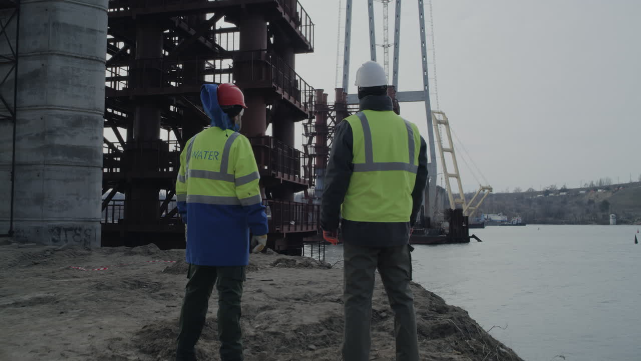 trabajadores de la construcción de puentes en la orilla de un río