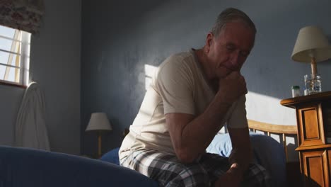 senior man lying on bed at home