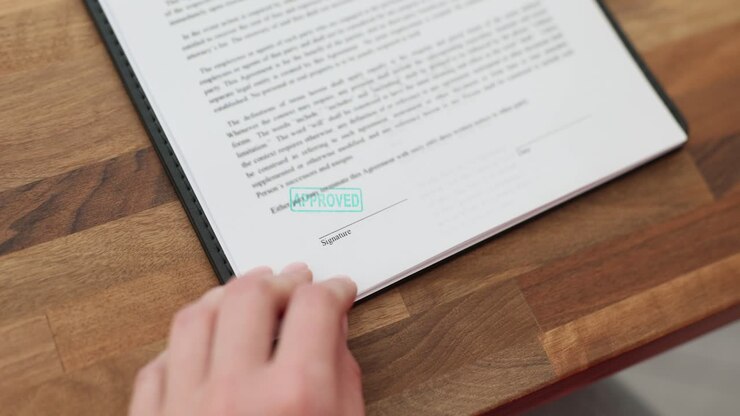 A hand approves a document