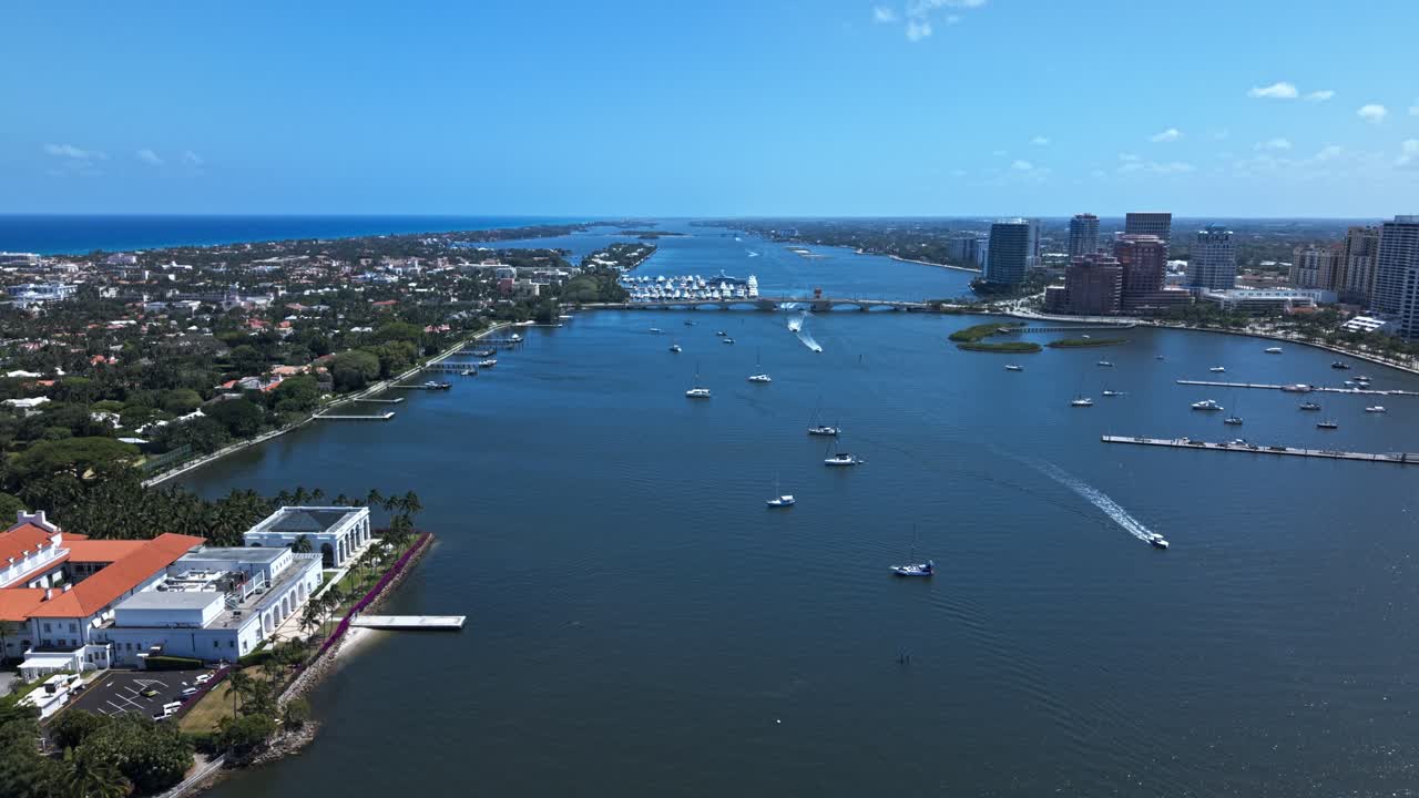 Aerial: downtown West Palm Beach cityscape, harbor and marina with yachts during the day in Florida, USA, push in drone shot