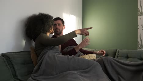 happy couple talking while watching movie at home