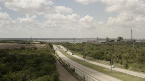 a two sided highway in a growing lake town with a factory