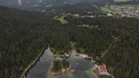 aerial view of lake caumasee, located in flims, lax, in the canton of graubünden, switzerland, highlighting the serene blue waters surrounded by lush forests and mountainous terrain.