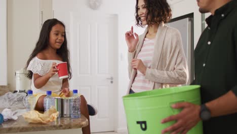 hispanic parents and daughter teaching segregating paper trash