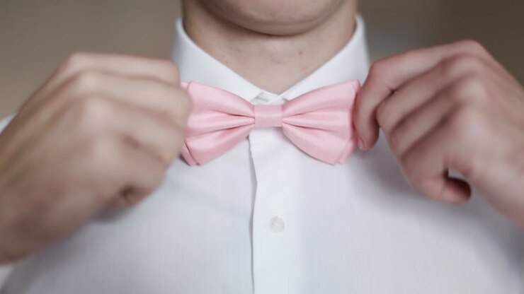 Uomo che indossa un papillon. Un uomo indossa un papillon, un uomo in camicia bianca