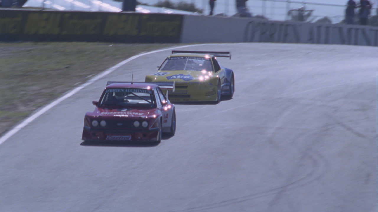 los autos de carrera corren alrededor de una pista