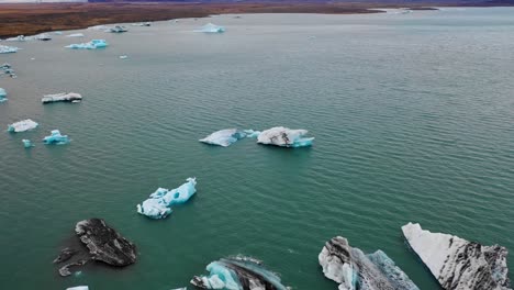 Überfliegen-Von-Eisbergen-Im-Jokulsarlon-Mit-Horizontalem-Flug-Und-Schwenk-Bis-Zur-Vatnajokull-Eiskappe