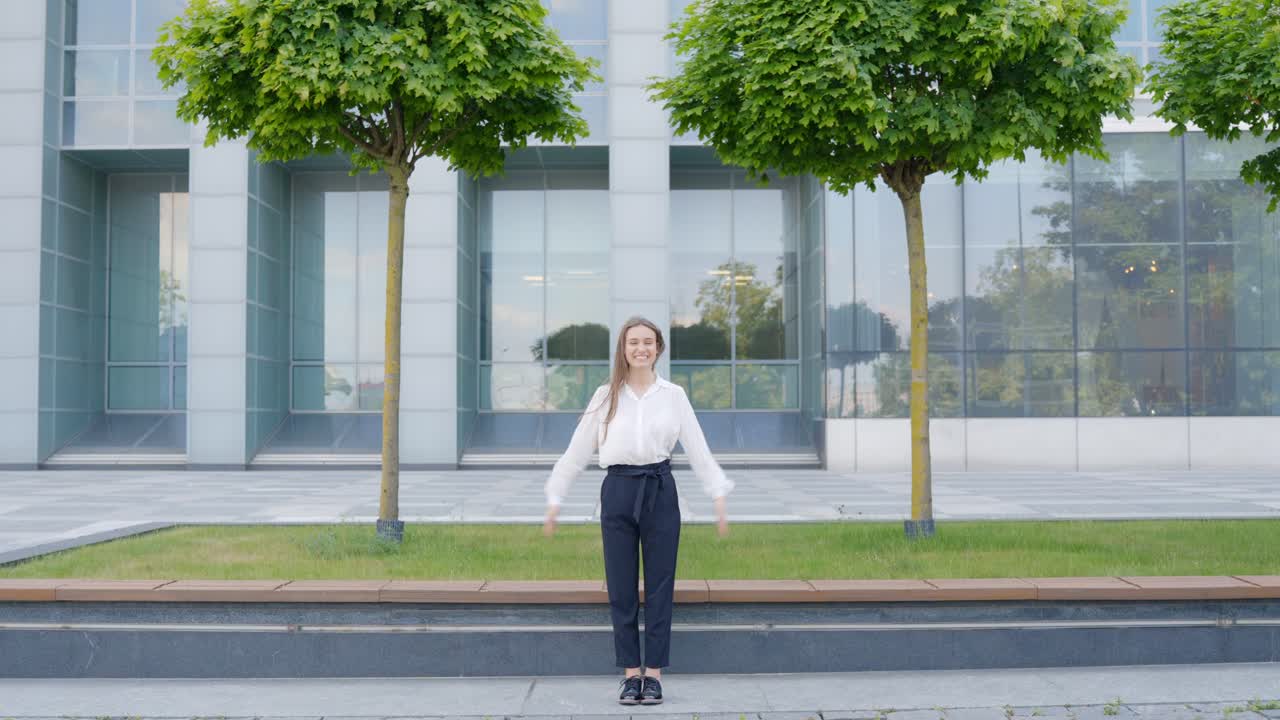 리가의 국립 도서관 앞에서 팔을 고 있는 행복한 여성