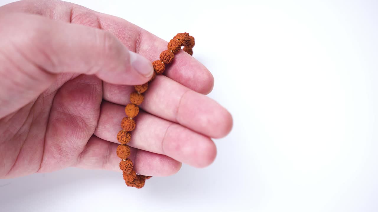 una persona que usa un brazalete de semillas de rudraksha subarni mala, panchmukhi semillas de rudraksha subarni mala brazalete con 27 cuentas. eficaz en el control del estrés.