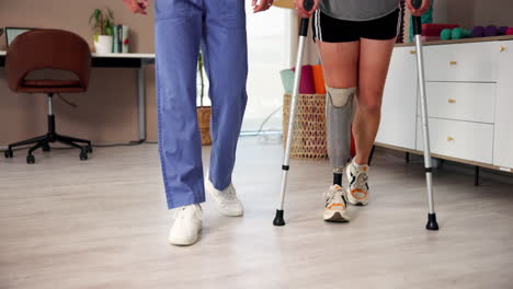 patient walking with crutches and prosthetic leg during physical therapy