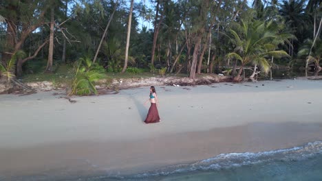 Girl-walking-alone-on-the-beach-through-the-waves