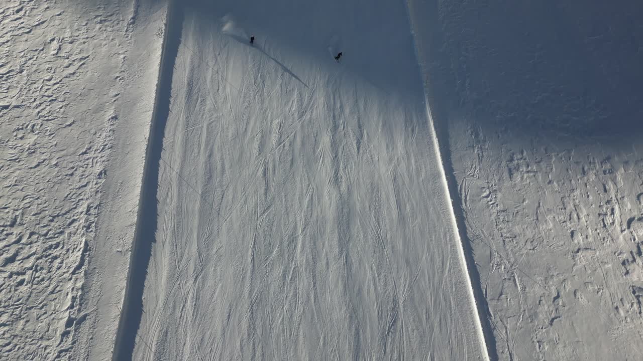 vista superior aérea de esquiadores alpinos en una pista de esquí de los alpes suizos