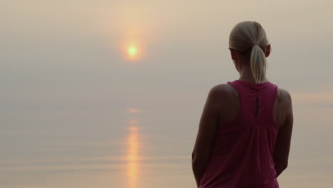 Mujer-Fitness-Segura-Mirando-El-Amanecer-Sobre-La-Vista-Trasera-Del-Mar