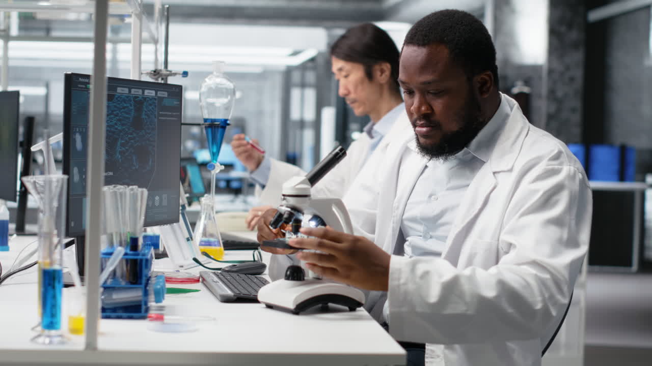 Vertical video Researcher operating compound microscope, doing sample observation