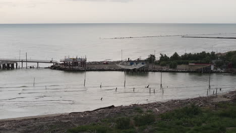 aerial view of fishing huts on shores of estuary at cloudy day,italian fishing machine, called ""trabucco"",lido di dante, ravenna near comacchio valley