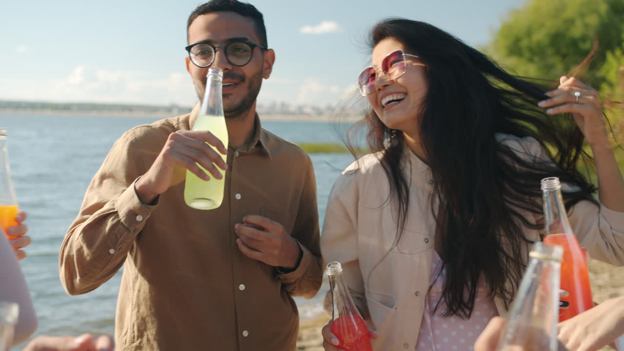 Friends enjoying drinks by the lake