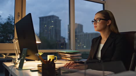 busy employee staying late in evening office. corporate trainee typing computer