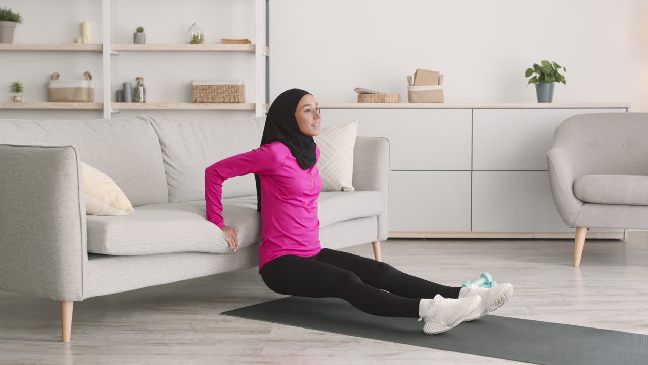 Woman in hijab doing push-ups at home