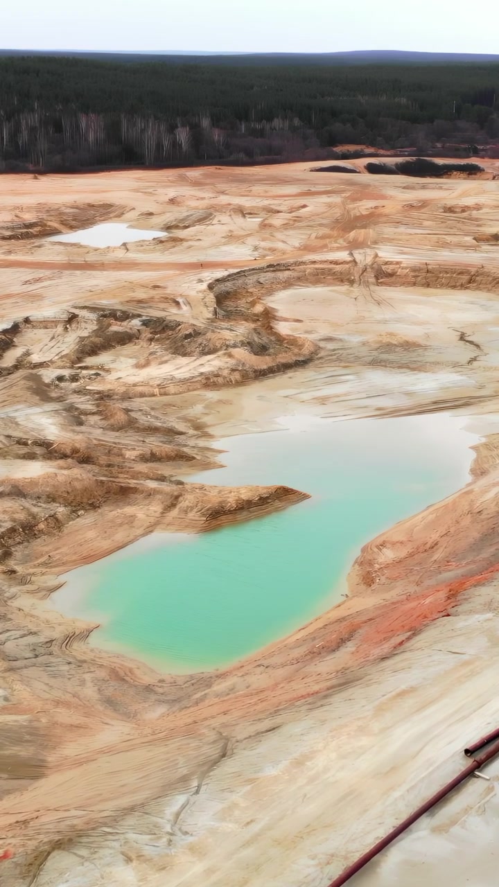 Aerial View Expansive Salt Flat And Emerald Pool Near Distant Treeline, Wide Bleached Surfaces And Tiny