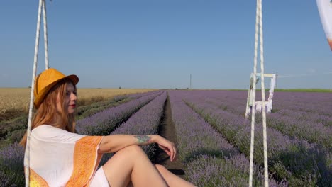 Pull-out-on-hippie-style-young-woman-relaxing-on-a-pallet-swing