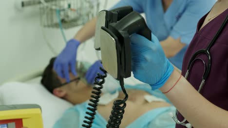 los médicos hacen reanimación a un paciente masculino en la sala de emergencias. masaje cardíaco. desfibrilación.