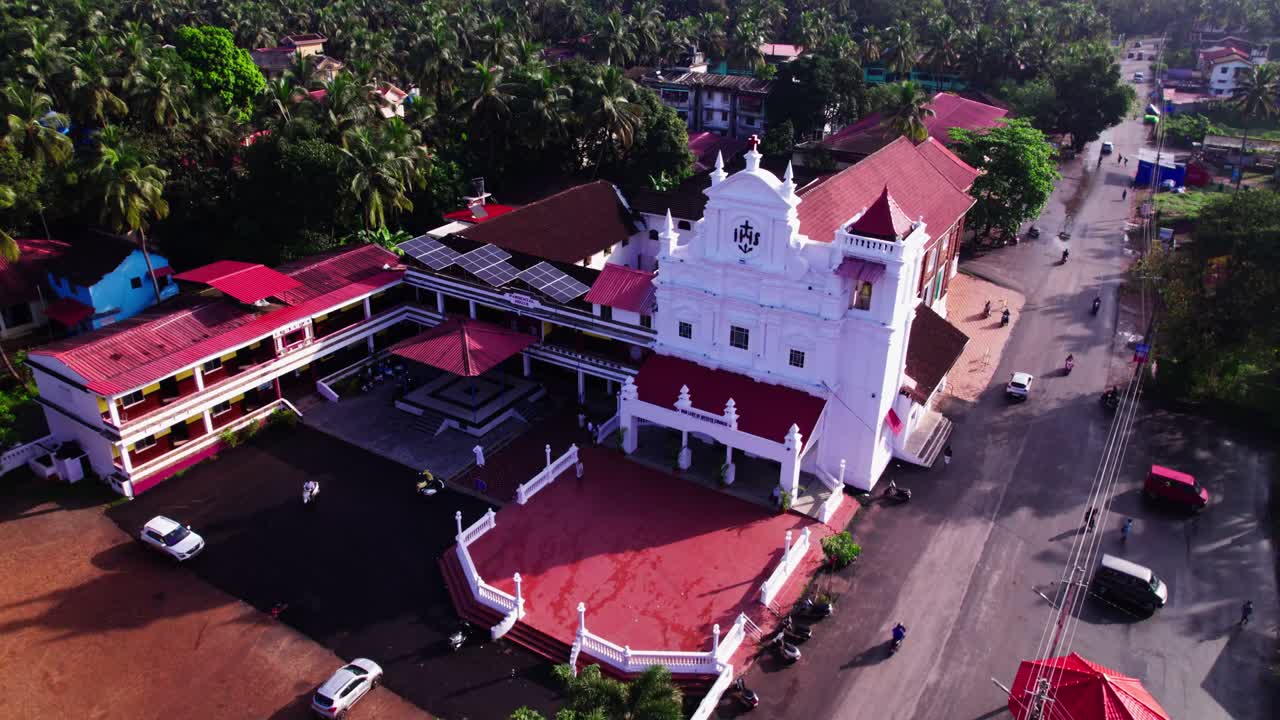 Our Lady of Merces Church with coconut trees and road at colva, south goa, india. day time, push back shot, drone shot, 4k