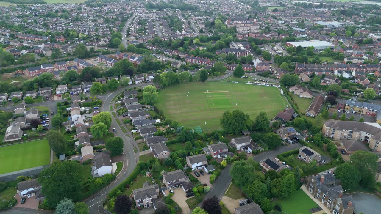 Aerial drone orbit panning footage of Oakham small town in England with cricket match played in rural UK Europe