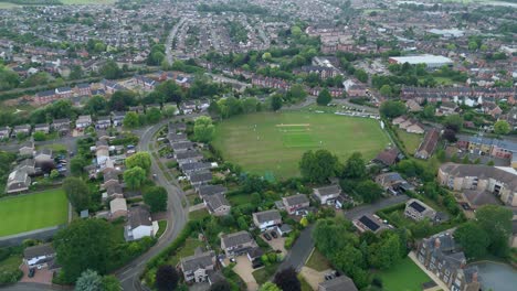 Aerial drone orbit panning footage of Oakham small town in England with cricket match played in rural UK Europe