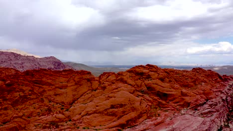 Aerial-Drone-shot-rising-up-above-the-Red-Rock-Canyon-Mountains-during-the-daytime-in-Las-Vegas-Nevada