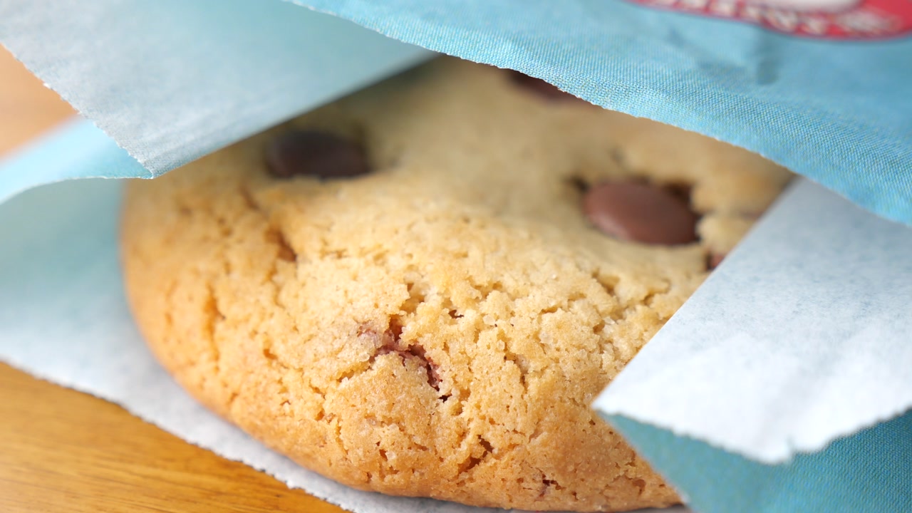 Delicious Chocolate Chip Cookie Partially Wrapped in Paper