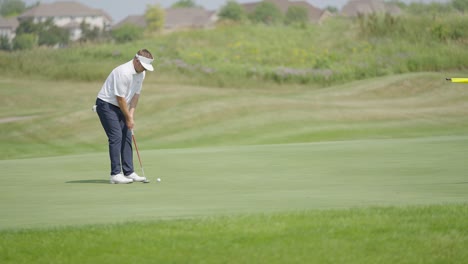 golfer putting on the green at a golf course