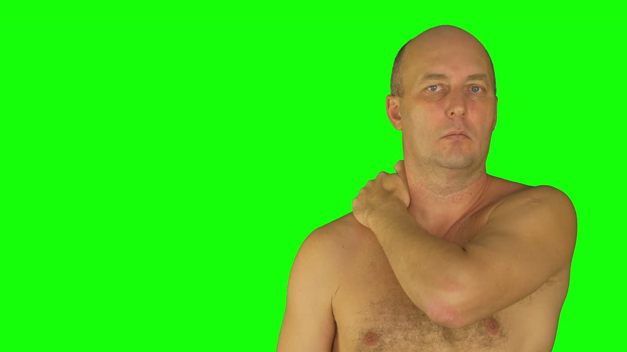 hombre frotando los hombros con la mano izquierda. vista delantera desnudo de cintura hacia arriba.