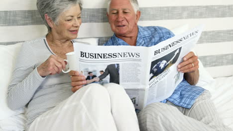 Happy-senior-couple-reading-a-newspaper