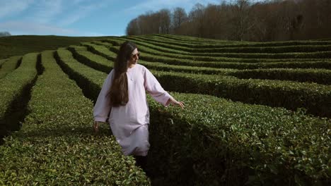 woman in a pink dress at a tea plantation